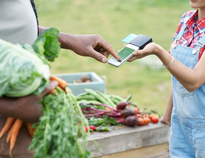 Man paying for veg at community stall